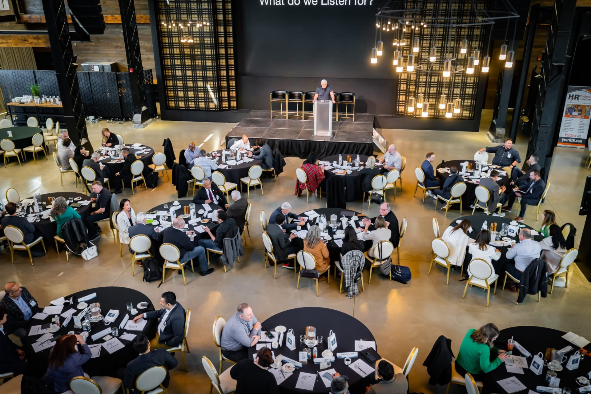 Leaders seated at round tables during an Inspire and Connect event